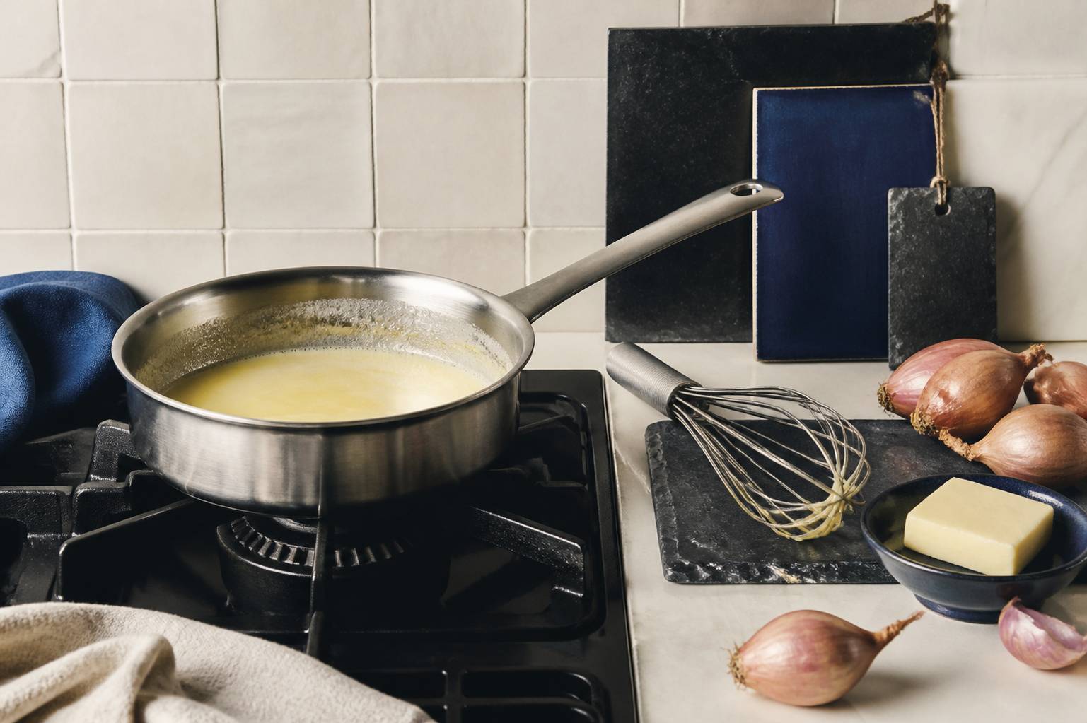 Préparation d'une émulsion au beurre blanc : fouet et casserole sur un feu doux en cuisine