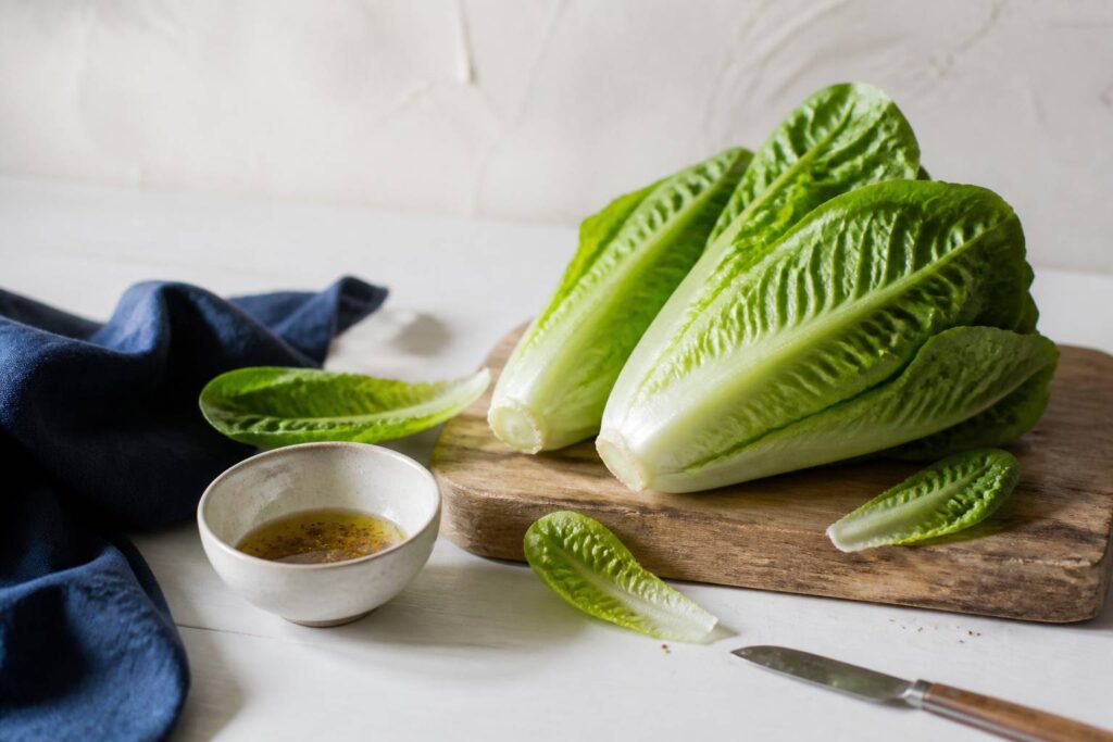 Salade sucrine croquante sur une planche en bois avec vinaigrette